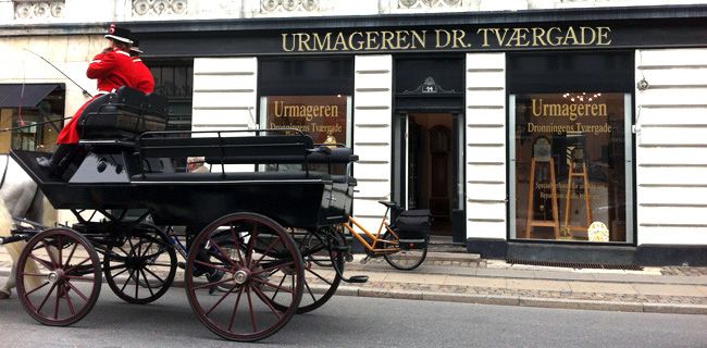 <h1>Urmageren Dr. Tværgade</h1><p>Stemningsbillede af urmageren´s facade, fra den hyggelige Dronningens Tværgade i hjertet af det historiske København.</p>